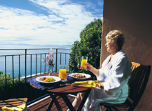 Guest enjoying breakfast on the deck at The Haven with ocean views