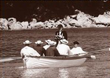 Historic photograph of people seated in a rowboat near the shoreline